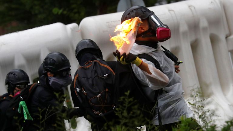 Des manifestants jettent des cocktails Molotov sur un bâtiment gouvernemental lors d'une manifestation à Hong Kong, Chine samedi
