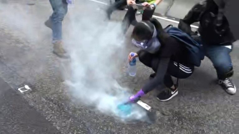 Des manifestants traitent des cartouches de gaz lacrymogène tirées par la police à Hong Kong