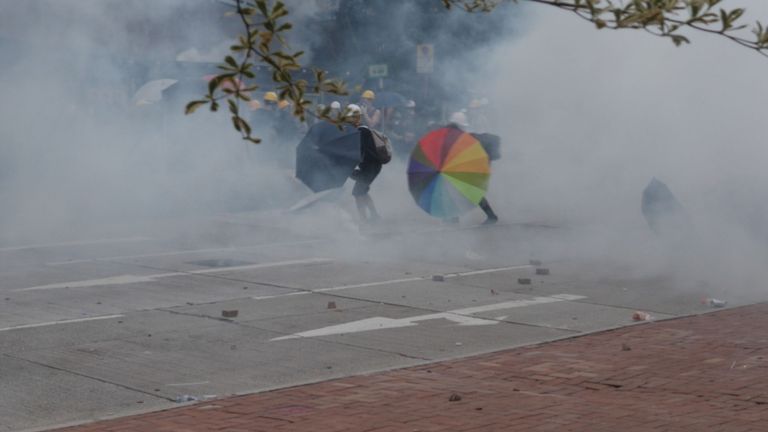 Les manifestants poussent à travers le gaz lacrymogène