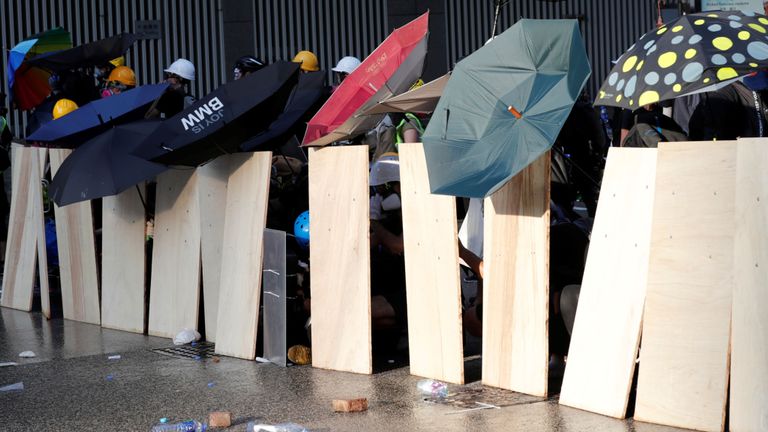 Les manifestants utilisent des parapluies pour former une barricade