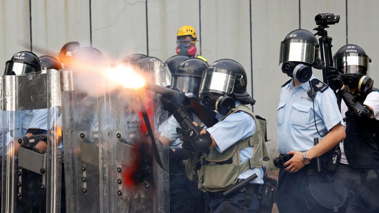 Des officiers de police tirent des gaz lacrymogènes alors que des manifestants contre des projets de loi anti-extradition manifestent dans le quartier de Sham Shui Po à Hong Kong, Chine, le 11 août 2019. 