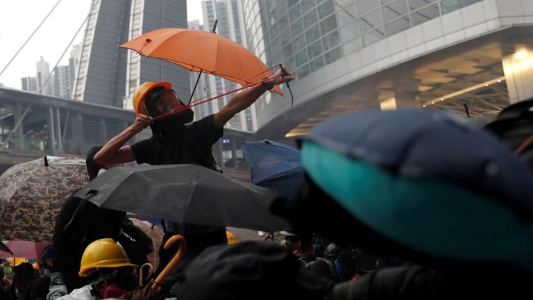 Un manifestant utilise une catapulte alors que des manifestants s'affrontent avec la police anti-émeute