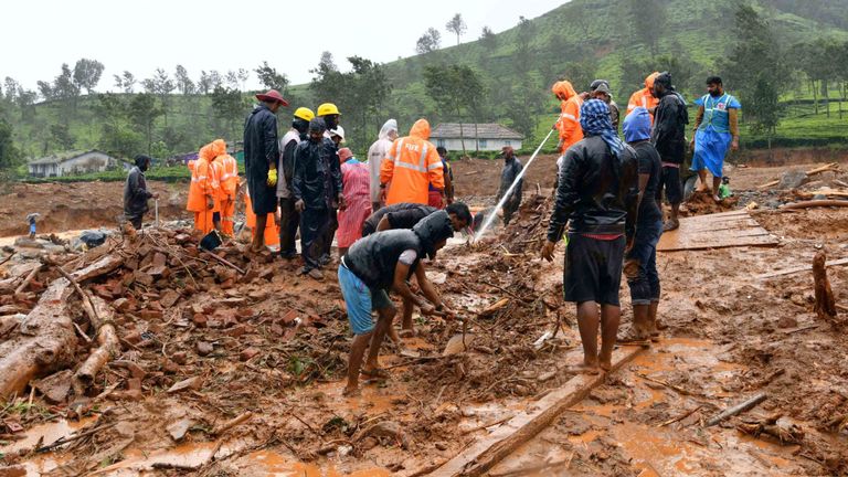 Les sauveteurs enlèvent les débris alors qu'ils recherchent les victimes d'un glissement de terrain causé par les pluies torrentielles de mousson à Meppadi 