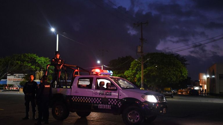 Des policiers montent la garde devant le bar Caballo Blanco (bar White Horse) où 23 personnes ont été tuées par un incendie à Coatzacoalcos, dans l'État de Veracruz, au Mexique, le 28 août 2019. - Au moins 23 personnes ont été tuées et 13 grièvement blessées dans un incendie a éclaté mardi soir au bar alors qu'une enquête est en cours d'investigation, ont annoncé mercredi les autorités. L’état de Veracruz est un point chaud dans les guerres sanglantes entre les cartels de drogue rivaux du Mexique. (Photo de VICTORIA RAZO / AFP) (Le crédit photo devrait se lire comme suit: