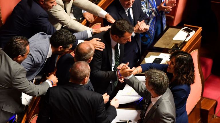Des membres du parti d'extrême droite de la Ligue félicitent le Vice-Premier ministre et ministre de l'Intérieur Matteo Salvini (C) à la suite de son discours devant le Sénat italien à Rome le 20 août 2019