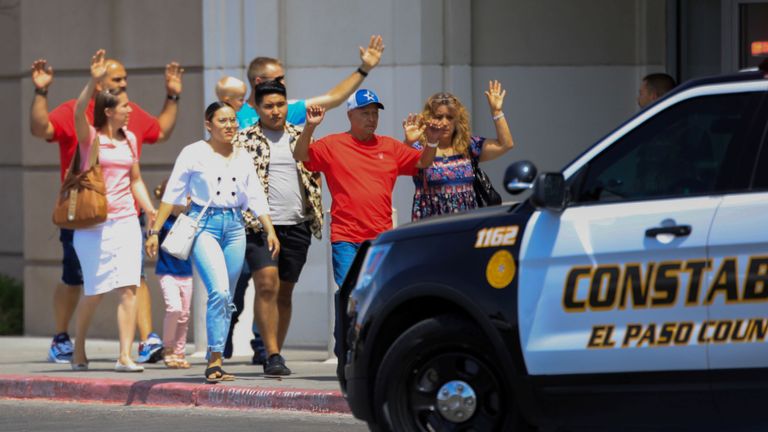 Les clients sortent les mains en l'air après une fusillade en masse dans un Walmart à El Paso