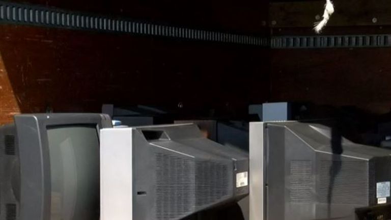 Screengrab d'un paquet NBC12 sur un homme capturé par CCTV portant une télévision, qui dépose les vieux appareils à l'extérieur des maisons des personnes
