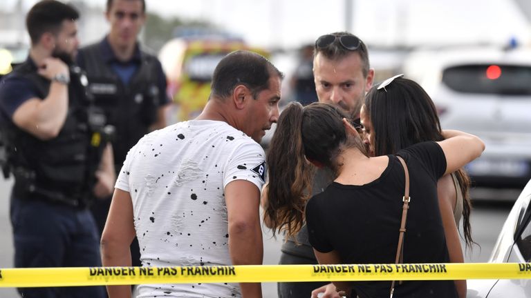 Un témoin (D) est réconforté par des amis à Villeurbanne en banlieue de Lyon le 31 août 2019, après une attaque au couteau qui a fait un mort et six blessés. - Deux hommes, l'un avec un couteau et l'autre avec une brochette, ont lancé l'attaque à Villeurbanne, dans le sud-est de la France, sans donner plus de détails sur le motif de l'agression. (Photo de PHILIPPE DESMAZES / AFP) (Le crédit photo devrait correspondre à PHILIPPE DESMAZES / AFP / Getty Images)