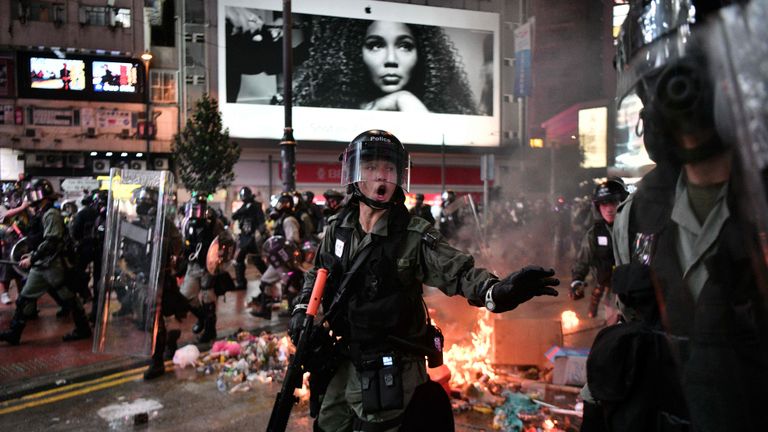 TOPSHOT - La police passe à côté de débris incendiés par des manifestants dans la région de Causeway Bay à Hong Kong le 31 août 2019, alors que les gens manifestent, défiant une interdiction de rassemblement - et des menaces croissantes venant de Chine - de descendre dans la rue pour la 13e week-end droit. (Photo par Anthony WALLACE / AFP) (Le crédit photo devrait correspondre à ANTHONY WALLACE / AFP / Getty Images)