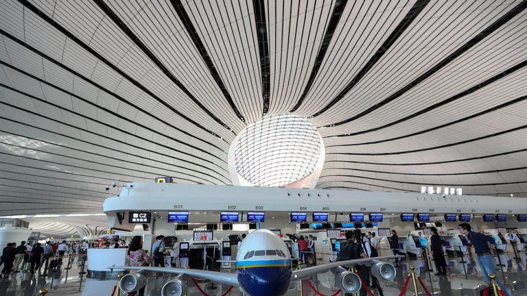 Des personnes marchent à l'intérieur du nouvel aéroport international de Beijing Daxing lors de sa première journée d'opération à Beijing, le 25 septembre 2019. - Le nouvel aéroport futuriste de Beijing, qui devrait devenir l'un des plus achalandés au monde, a été ouvert par le président chinois Xi Jinping le 25 septembre. (Photo de STR / AFP) / China OUT (le crédit photo devrait correspondre à STR / AFP / Getty Images)