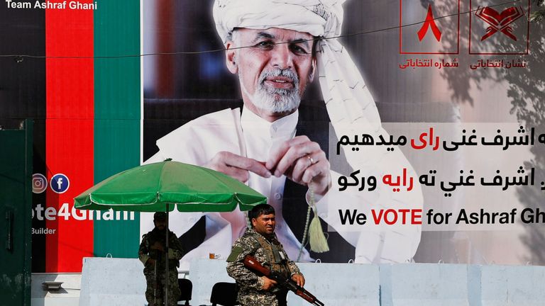 Un membre des forces de sécurité afghanes se tient devant une affiche du candidat à la présidentielle afghan Ashraf Ghani