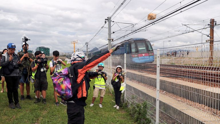 Un manifestant jette une pierre sur une voie ferrée près de l'aéroport