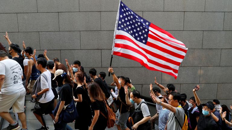 Les manifestants brandissent cinq doigts et un drapeau américain alors qu'ils se dirigeaient vers le consulat général des États-Unis à Hong Kong