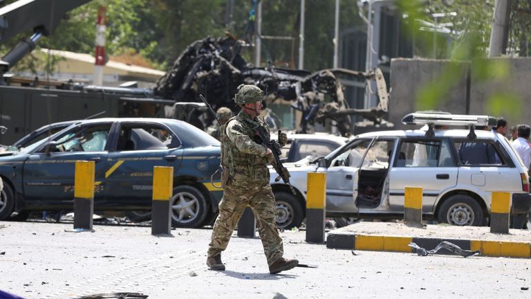 Un soldat étranger affecté à la mission de soutien Resolute dirigée par l'OTAN inspecte le site de l'attaque