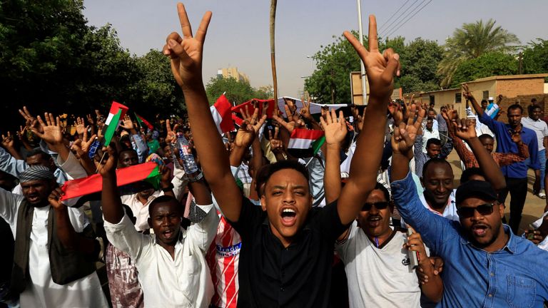 Des manifestants soudanais élèvent des signes de victoire alors que le président Omar al Bashir se retire