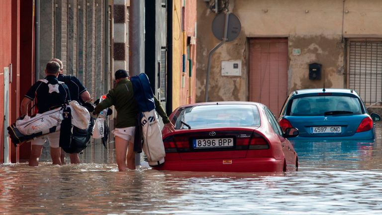 Les gens marchent dans une rue inondée à Almoradi 