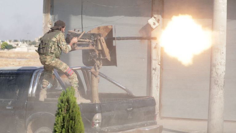 Un combattant rebelle syrien soutenu par la Turquie tire une arme dans la ville de Tal Abyad