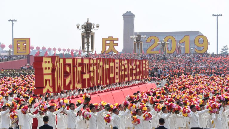 Un char avec un slogan intitulé "Mettez en œuvre la pensée Xi Jinping sur le socialisme avec des caractéristiques chinoises pour une nouvelle ère" passe sur la place Tiananmen lors du défilé de la Fête nationale à Beijing le 1er octobre 2019, à l'occasion du 70e anniversaire de la fondation du Peuple République de Chine. (Photo par GREG BAKER / AFP) (Le crédit photo doit correspondre à GREG BAKER / AFP / Getty Images)