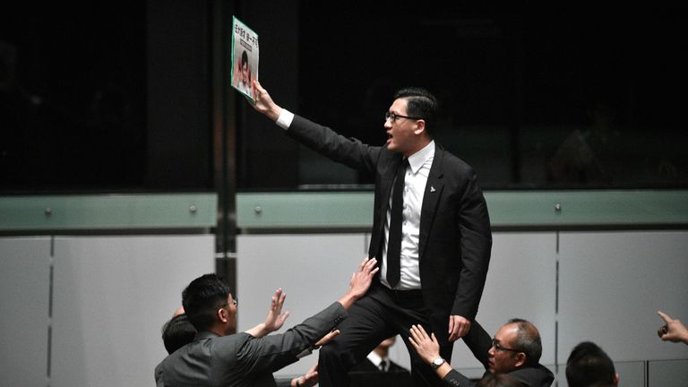 Le législateur pro-démocratie Lam Cheuk-ting (C) se lève et proteste peu avant que la directrice générale de Hong Kong, Carrie Lam (non représentée), quitte la salle pour la deuxième fois alors qu'elle tentait de présenter son discours politique annuel devant le Conseil législatif (Legco) de Hong Kong, le 16 octobre 2019. - La dirigeante assaillie de Hong Kong a abandonné le 16 octobre un discours sur l'état de l'Union, après qu'elle ait été chahutée par les législateurs de l'opposition lors de scènes chaotiques à l'intérieur de la législature de la ville. (Photo par Anthony WALLACE / AFP) (Photo par ANTHONY WALLACE / AFP via Getty Images)