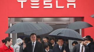 M. Musk marche avec le maire de Shanghai, Ying Yong, sous la pluie