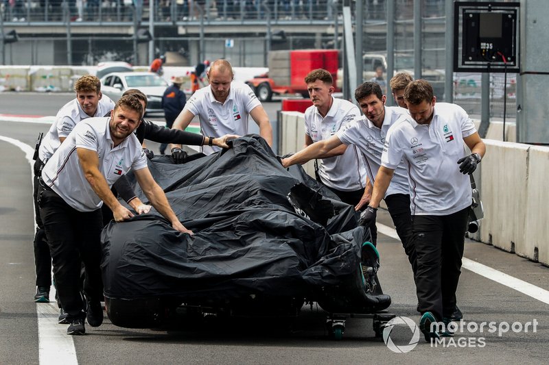 Les mécaniciens de Mercedes rendent la voiture endommagée de Valtteri Bottas, la Mercedes AMG W10, à leur garage après son accident à la fin des qualifications.