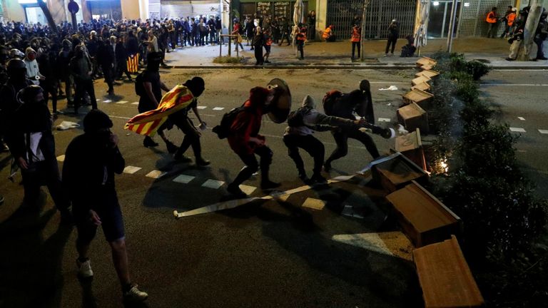 Les manifestants sont vus derrière une barricade lorsqu'ils se heurtent à la police