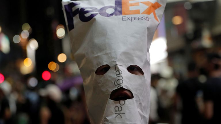 Un manifestant anti-gouvernemental porte un masque fabriqué avec une enveloppe FedEx lors d'une manifestation à Hong Kong, Chine