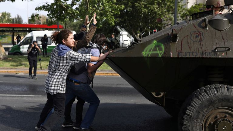 Des manifestants photographiés devant un véhicule de l'armée