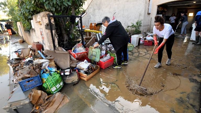 Une femme à Béziers nettoie sa maison à la suite des inondations