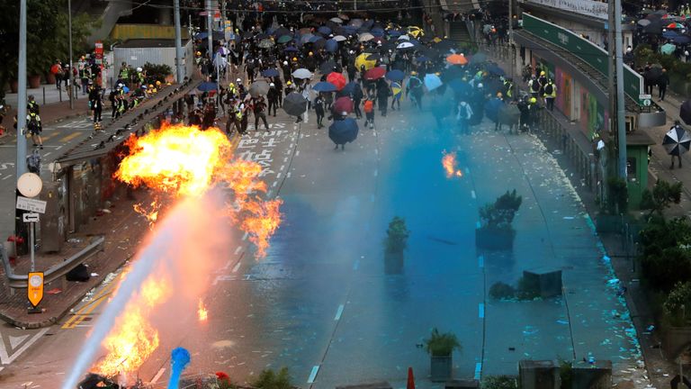 La police anti-émeute pulvérise de l'eau bleue lors d'une manifestation à l'occasion de la fête nationale chinoise à Hong Kong