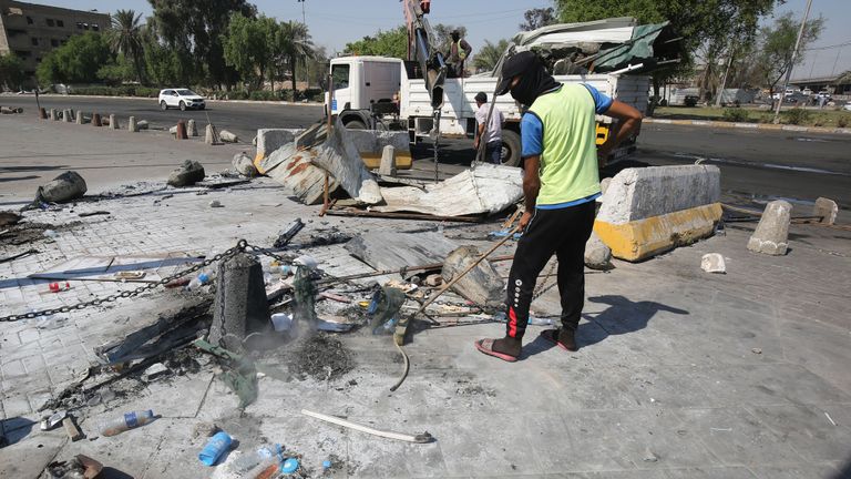 Des ouvriers ramassent des balles et des débris samedi matin