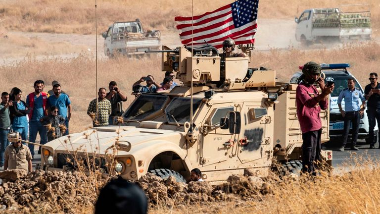 Des Kurdes syriens se rassemblent autour d'un véhicule blindé américain lors d'une manifestation contre les menaces turques de les attaquer