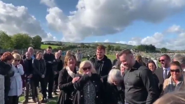 Les personnes en deuil rigolent alors que la voix de Shay Bradley se fait entendre au-delà de la tombe