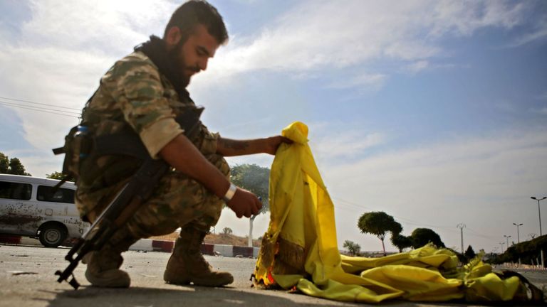 Un combattant syrien soutenu par la Turquie a brûlé le drapeau des Forces démocratiques syriennes (SDF) dans la ville d'Ayn al-Arus, au sud de la ville frontalière de Tal Abyad, le 14 octobre 2019, alors que la Turquie et ses alliés poursuivent leur assaut Villes frontalières tenues par les Kurdes dans le nord-est de la Syrie. - Les forces du régime syrien se sont dirigées vers la frontière turque après la conclusion d'un accord entre Damas et les forces kurdes assiégées à la suite d'une annonce du retrait américain, ont rapporté les correspondants de l'AFP. (Photo de Bakr ALKASEM / AFP) (Photo de 