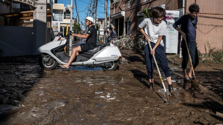 Des personnes évacuent la boue de leurs maisons après avoir été inondées lors du typhon Hagibis, le 13 octobre 2019 à Kawasaki, au Japon.