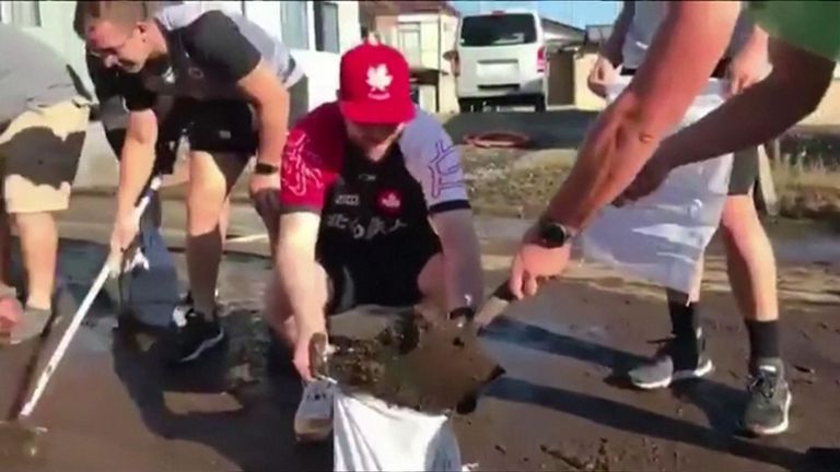 Les joueurs canadiens sont descendus dans les rues pour pelleter la boue et nettoyer les débris après le passage de la tempête.