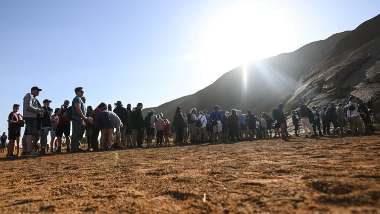 Les touristes font la queue pour monter Uluru