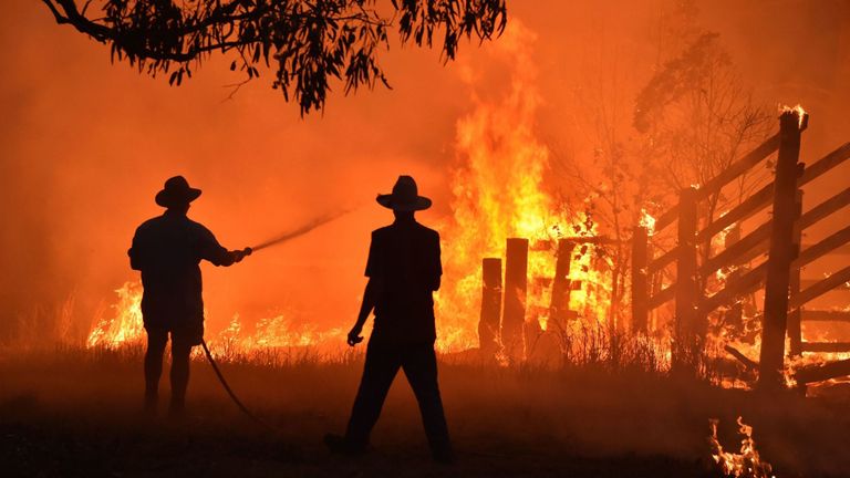 Les résidents défendent une propriété d'un feu de brousse à Hillsville, près de Taree, à 350 km au nord de Sydney le 12 novembre 2019.