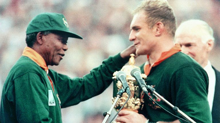 Photo prise le 24 juin 1995 à Johannesburg montrant le président sud-africain Nelson Mandela (à gauche) félicitant François Pienaar, skipper du Springbok, pour lui avoir remis le trophée William Webb Ellis. - Les Springboks ont battu la Nouvelle-Zélande 15 à 12 après une prolongation de la finale de la Coupe du monde de rugby. (Photo de Jean-Pierre MULLER / AFP) (Le crédit photo doit correspondre à JEAN-PIERRE MULLER / AFP via Getty Images)