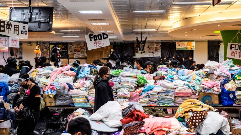 Sur cette photo prise le 14 novembre 2019, des manifestants défilent entre des rayons de marchandises données par des membres du public à la Hong Kong Polytechnic University de Hung Hom, à Hong Kong. - Les manifestations qui ont débuté contre un projet de loi d'extradition vers la Chine, actuellement en suspens, ont débouché sur de plus grands appels à la démocratie et à la responsabilisation de la police alors que la violence et les manifestations envahissent la ville, mettant en cause l'autorité de Pékin. (Photo par Anthony WALLACE / AFP) (Photo par ANTHONY WALLACE / AFP via Getty Images)