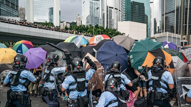 HONG KONG, HONG KONG - 1ER JUILLET: Les policiers utilisent des matraques pour disperser les manifestants anti-extradition lors d'un affrontement à l'extérieur du complexe du Conseil législatif avant la cérémonie annuelle de lever du drapeau du 22e anniversaire du transfert de la Grande-Bretagne à la Chine le 1er juillet 2019 à Hong Kong, en Chine. Des manifestants pro-démocrates à Hong Kong ont organisé des rassemblements au cours des dernières semaines pour demander le retrait d'un projet de loi controversé sur l'extradition, la démission de la directrice générale du territoire, Carrie Lam, une enquête sur les brutalités policières et l'abandon des charges d'émeute contre des manifestants pacifiques. (Photo par Anthony Kwan / Getty Images)