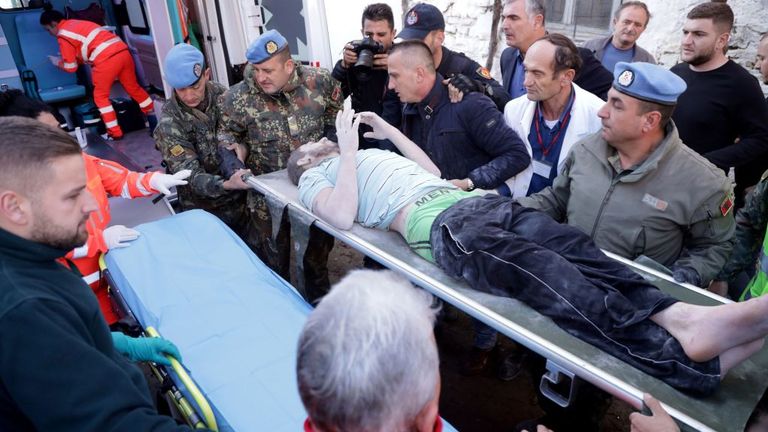Des secouristes transportent un survivant après l'avoir sauvé des décombres à Durres