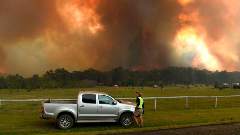 Les habitants observent les feux de brousse sur les terres agricoles près de la petite ville de Nana Glen