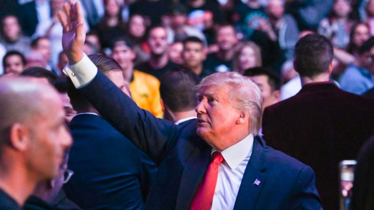 Le président américain Donald Trump salue la foule alors qu'il assiste à un match de l'UFC