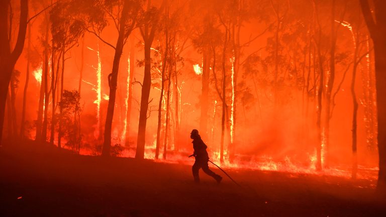 Un officier de pompiers et de secours de NSW protège l'école publique de Colo Heights contre l'incendie provoqué par l'incendie du mont Gospers près de Colo Heights, au sud-ouest de Sydney, en Australie, le 19 novembre 2019