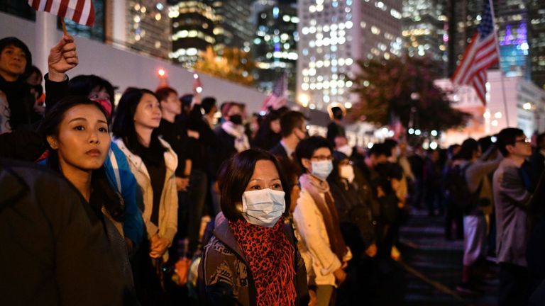 Des manifestants, certains masqués, agitent le drapeau national américain en remerciement de Donald Trump