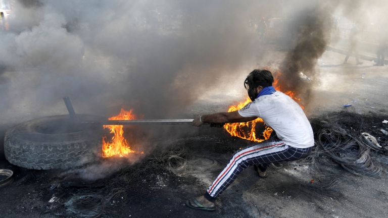 Un manifestant irakien tire un pneu brûlant lors de manifestations anti-gouvernementales