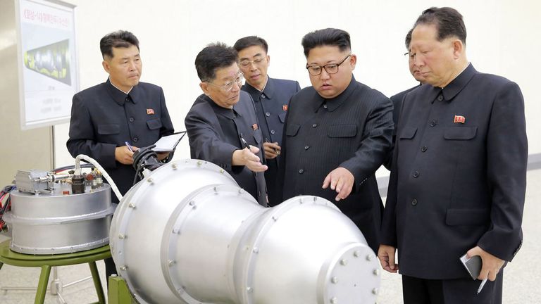 TOPSHOT - Cette image non datée publiée le 3 septembre 2017 par la KCNA, l’agence de presse centrale coréenne, montre le dirigeant nord-coréen Kim Jong-Un (C) en train de regarder un boîtier en métal avec deux renflements dans un lieu tenu secret. La Corée du Nord a mis au point une bombe à hydrogène qui peut être chargée dans le nouveau missile balistique intercontinental du pays, a annoncé le 3 septembre l'Agence de presse centrale coréenne, a déclaré l'agence centrale coréenne d'informations.