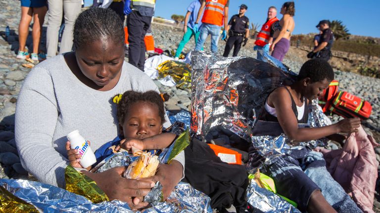 Une migrante est assise avec son enfant après qu'un groupe a atterri dans un canot à la plage d'Aguila, sur l'île de Grande Canarie, en Espagne, le 29 novembre 2019. REUTERS / Borja Suarez REFILE - CORRECTING LOCATION