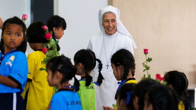 Sœur Ana Rosa Sivori sourit en marchant avec des élèves de l'école St. Mary dans la province d'Udon Thani